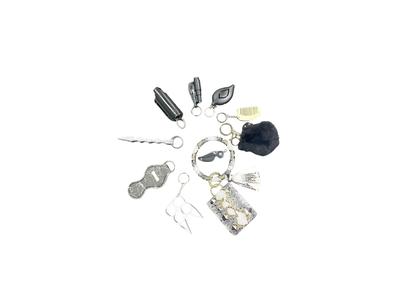 Snakeskin-patterned self-defense keychain set in silver and black, includes alarm, pepper spray holder, and emergency tools